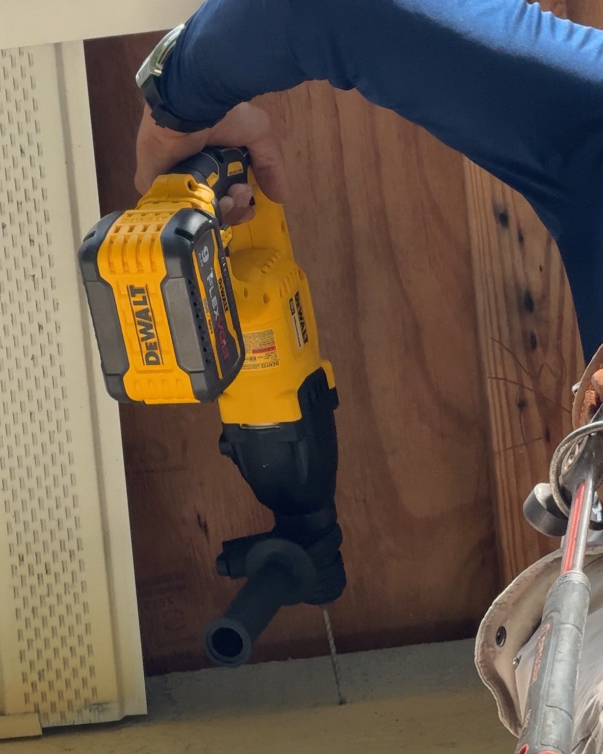 Detailed exterior repair work — fastening replacement wood behind soffit